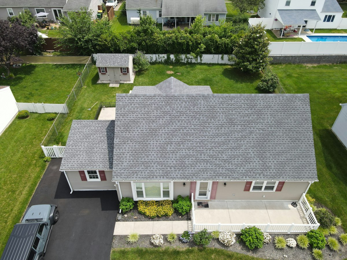 Aerial view of a suburban house with a freshly installed grey roof