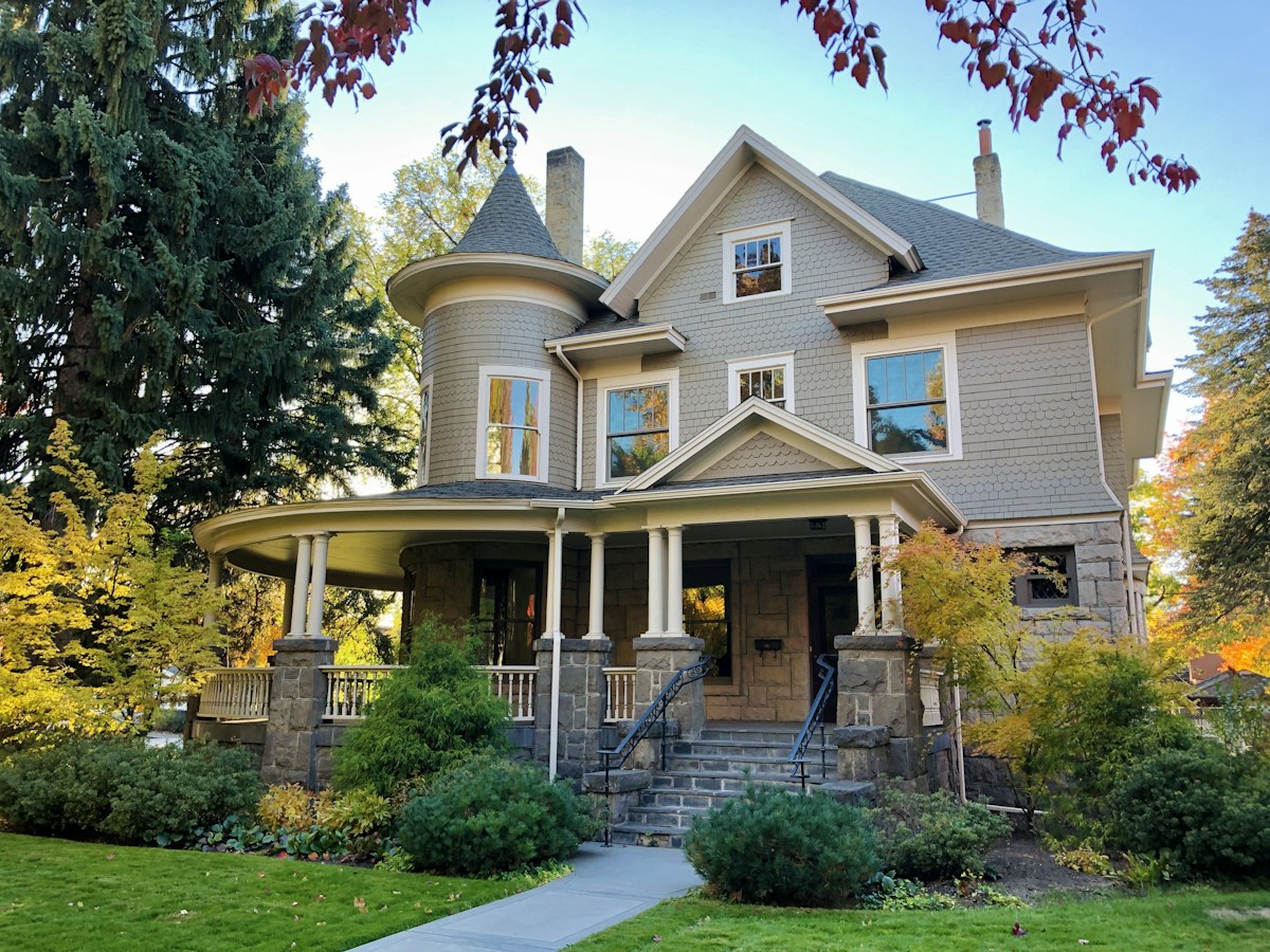 Victorian home with a well-maintained roof and autumn trees