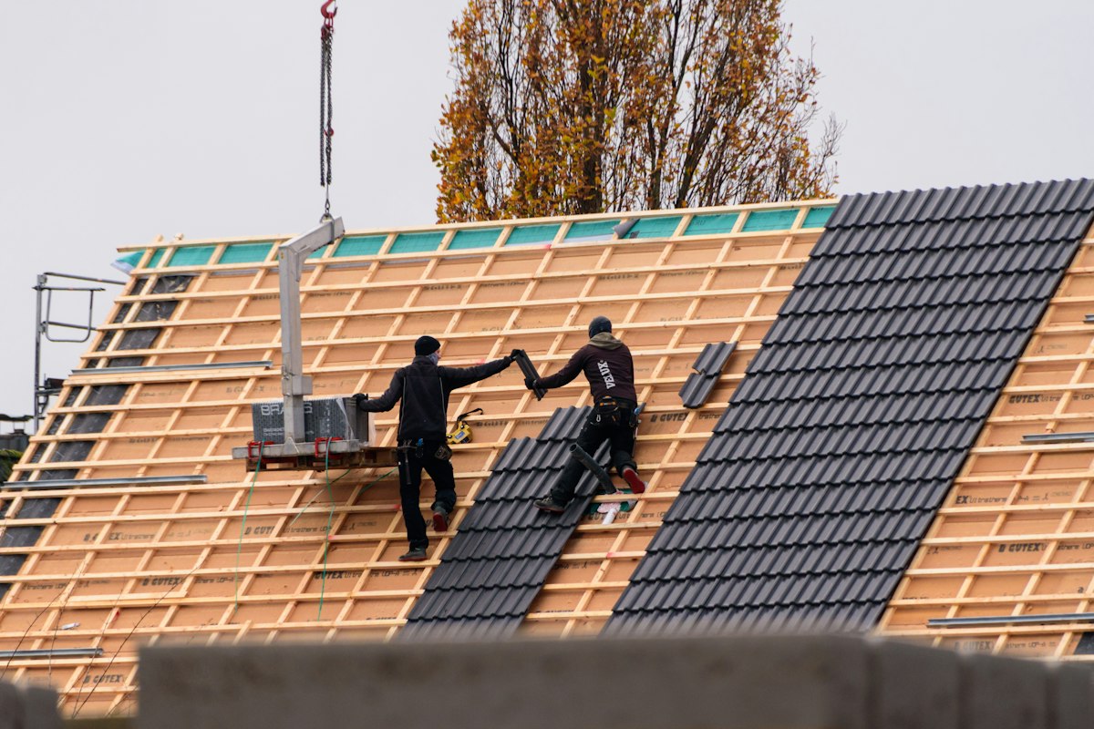 Crew installing new roof tiles on a building